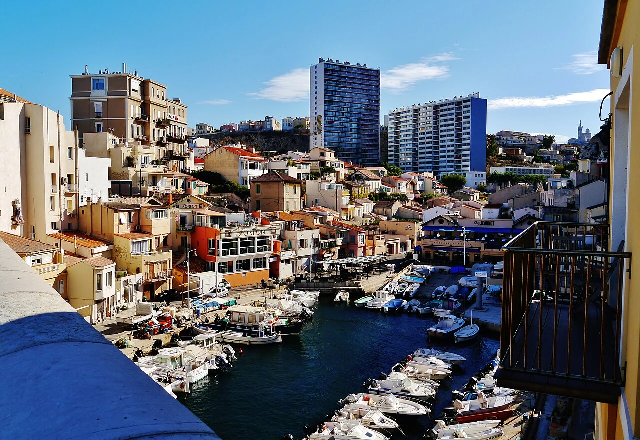Petit port du Vallon des Auffes : barques et maisons colorées vues depuis un balcon.