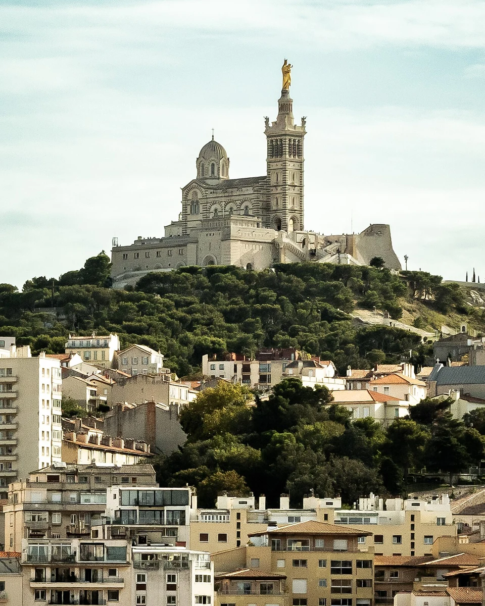 La basilique Notre-Dame de la Garde au sommet de sa colline, au-dessus des toits de Marseille.