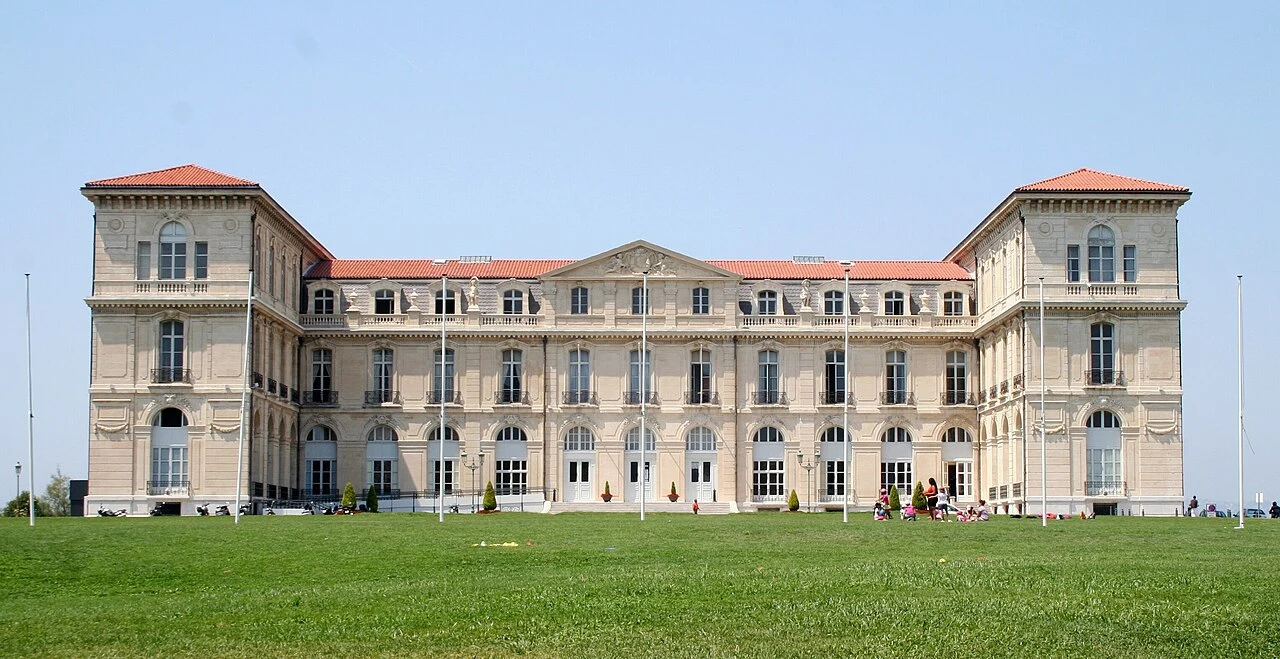 Façade du palais du Pharo derrière une grande pelouse.